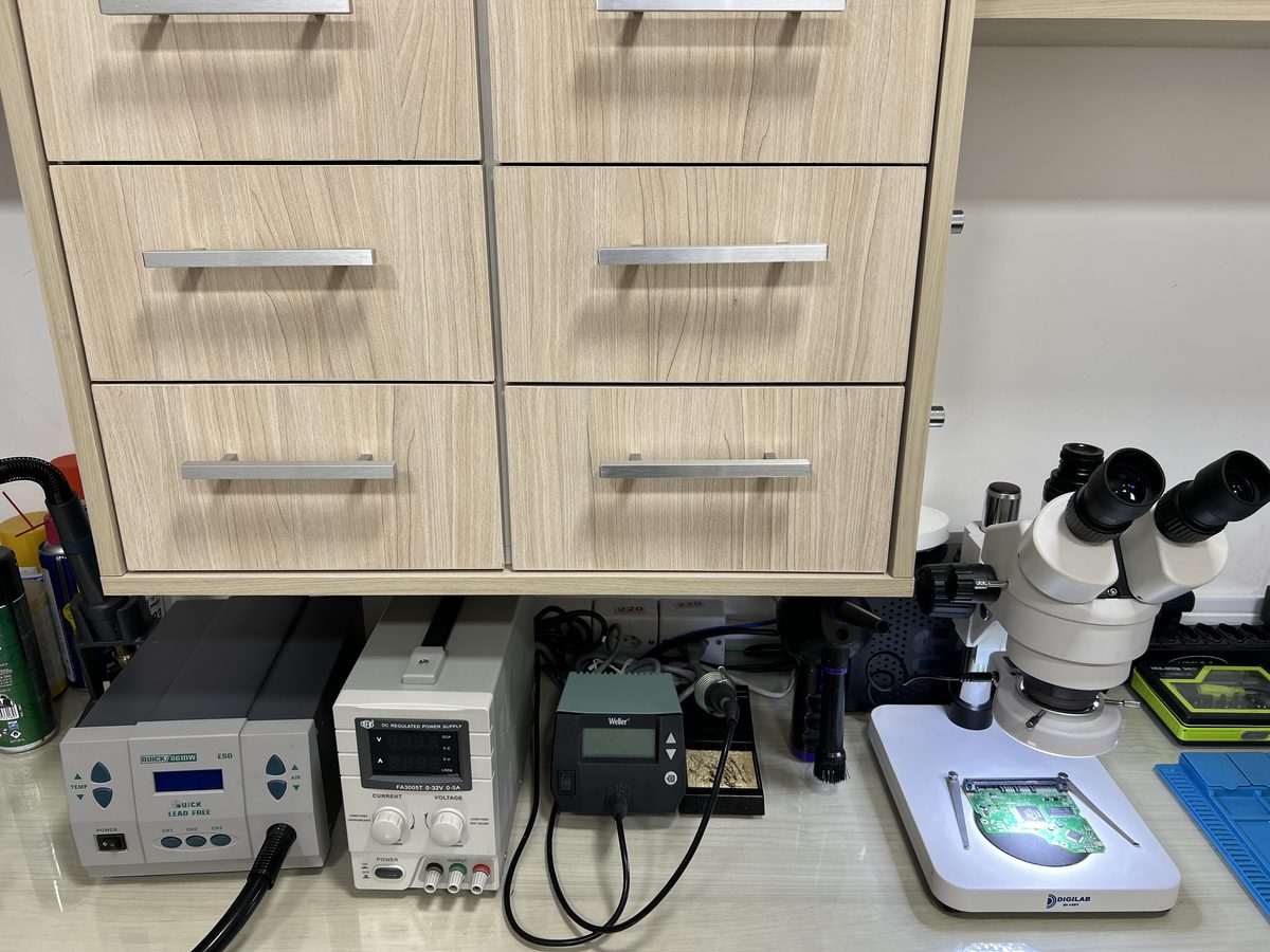 Enetsec forensics bench showing the microscope station, soldering and rework power supplies, and a six-drawer evidence storage cabinet